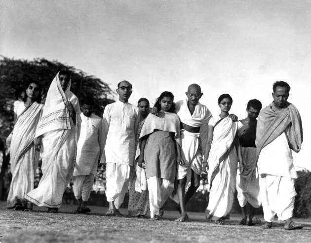 کپشن از مجله لایف: گاندی در جمع پیروان ستایشگرش هر روز صبح به پیاده‌روی می‌روند. در این عکس نوه‌اش سیتا (چپ) و عروسش ابها (راست) به او کمک می‌کنند.