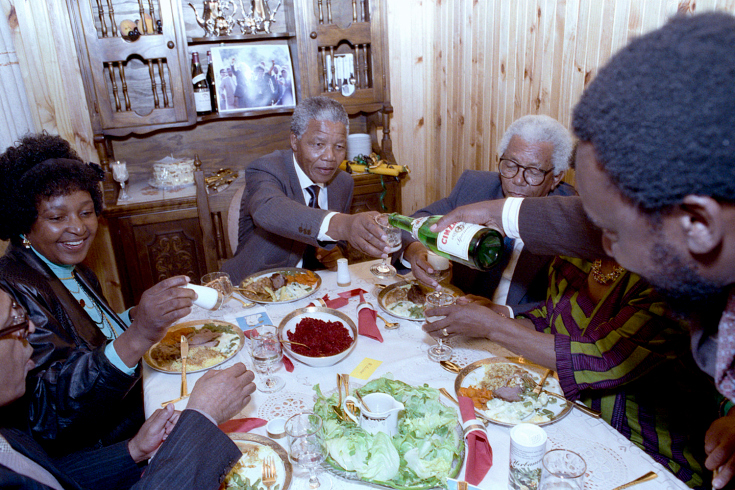 نلسون ماندلا اولین وعده غذایش را در کنار خانواده و والتر سیسولو هم‌بندی ۲۷ سال زندانش در خانه‌اش در سووتو صرف می‌کند. مردی که در تصویر نوشیدنی می‌ریزد سیریل رامافوسا است که امروزه از سوی بسیاری نامزد اصلی ریاست جمهوری آینده آفریقای جنوبی به حساب می‌آید.