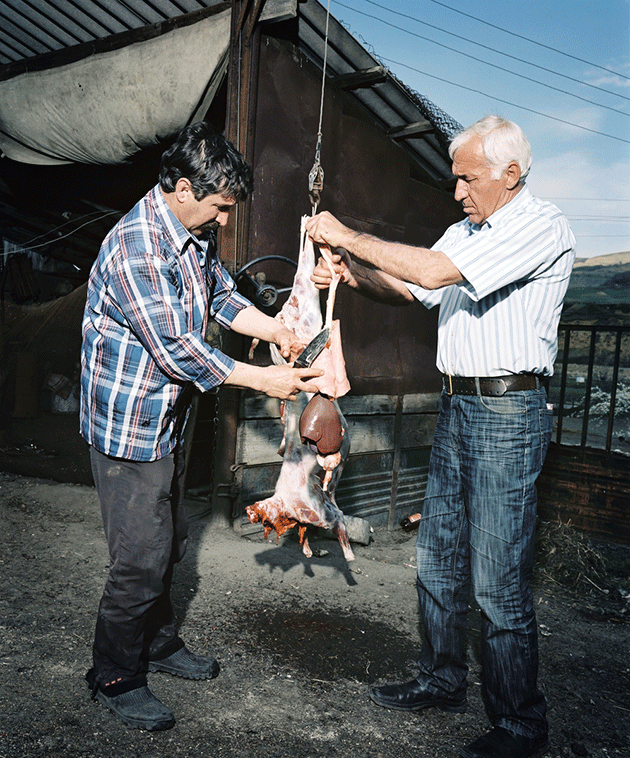 هوسی آیباسوف و گئورگی اکزکف یک بره را برای مهمانان‌شان قصابی می‌کنند. کرسنی وستک، روسیه، ۲۰۱۰